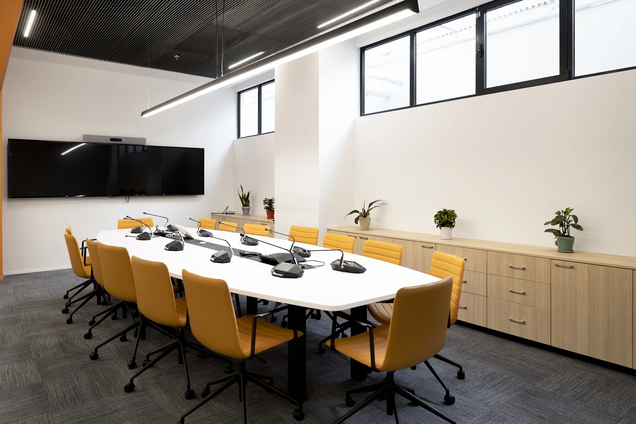 The meeting room with a long table and an orange accent ceiling
