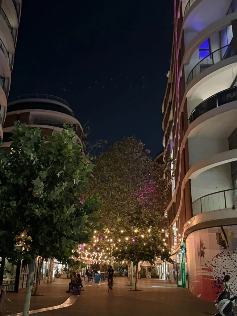 Illuminated pedestrian corridor between the residential towers at night