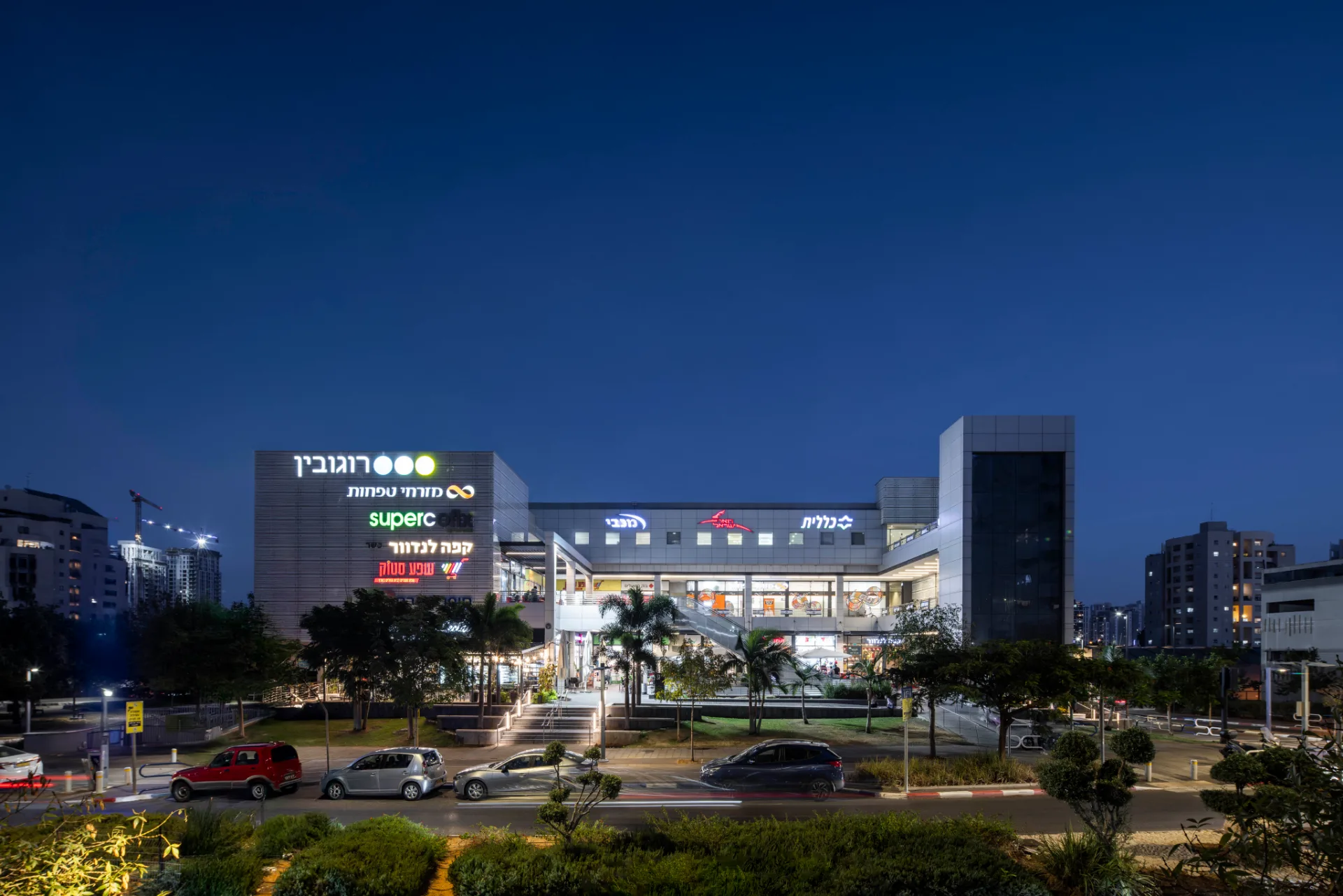 Street-level view of the lit center and its signage at dusk