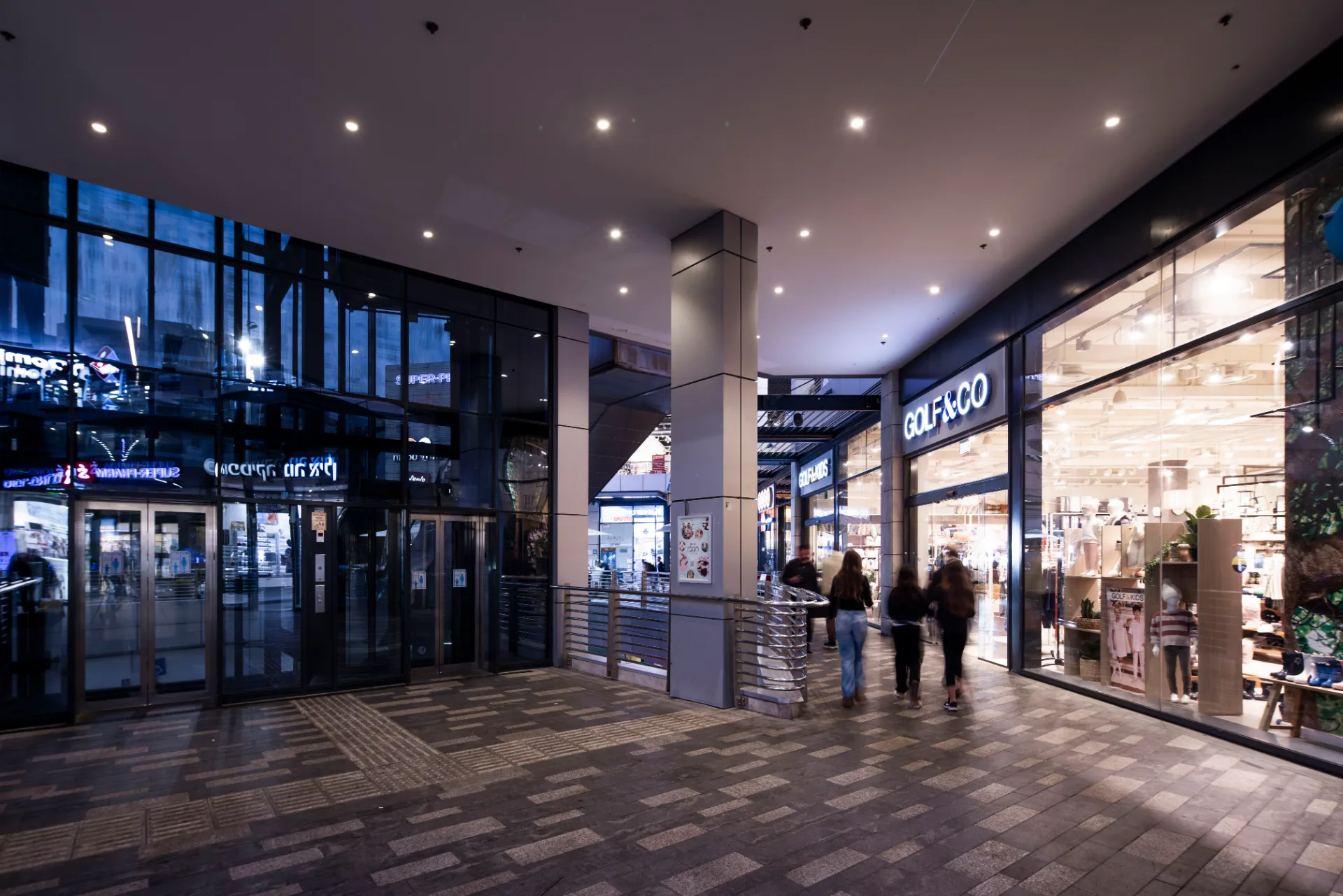 Glazed entrance frontage with lit storefronts