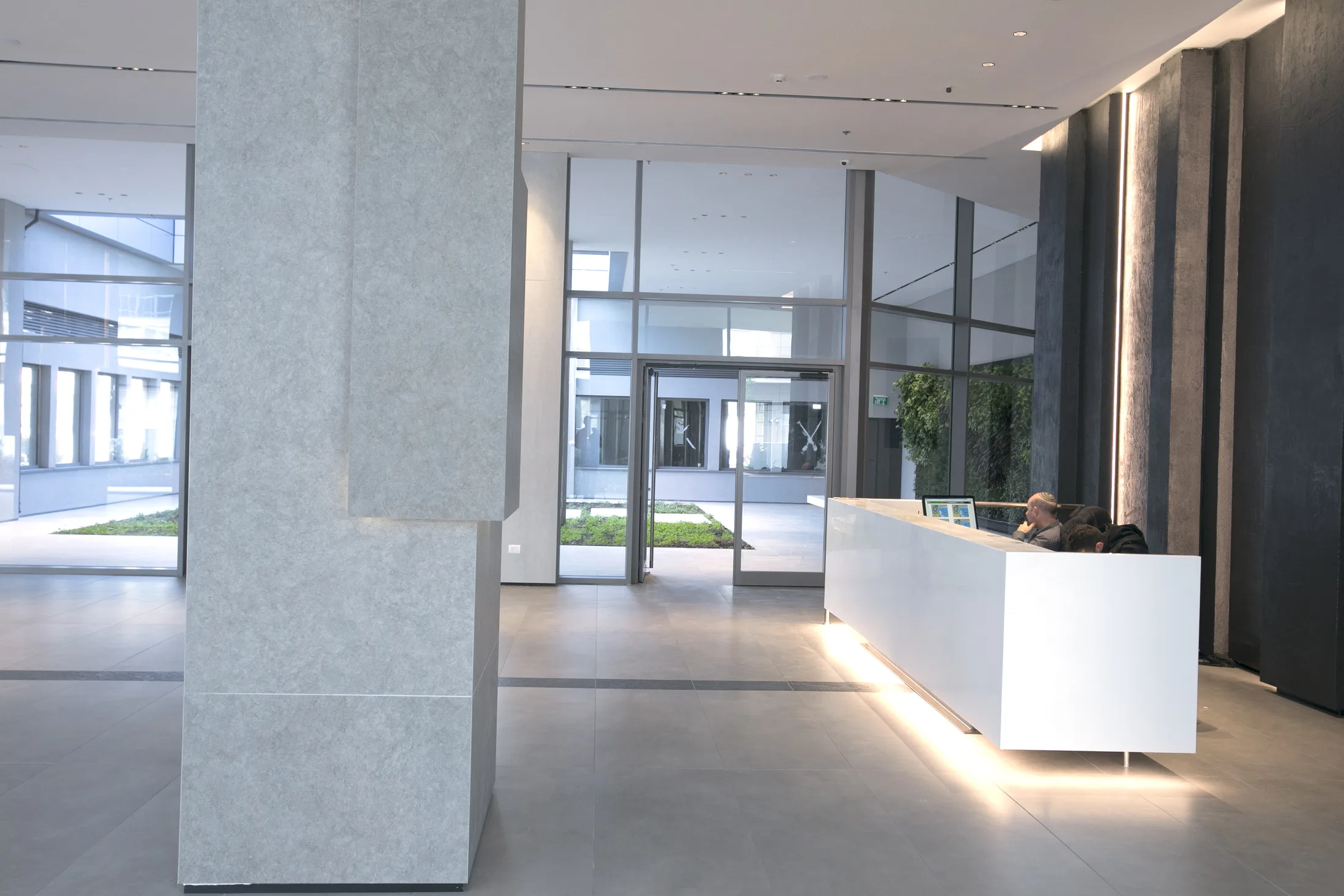 The entrance lobby with columns carrying vertical light grooves and a view to the courtyard