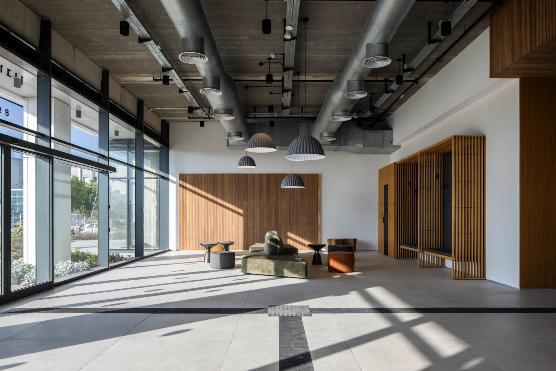 Lobby lounge with a timber wall and full-height glazing
