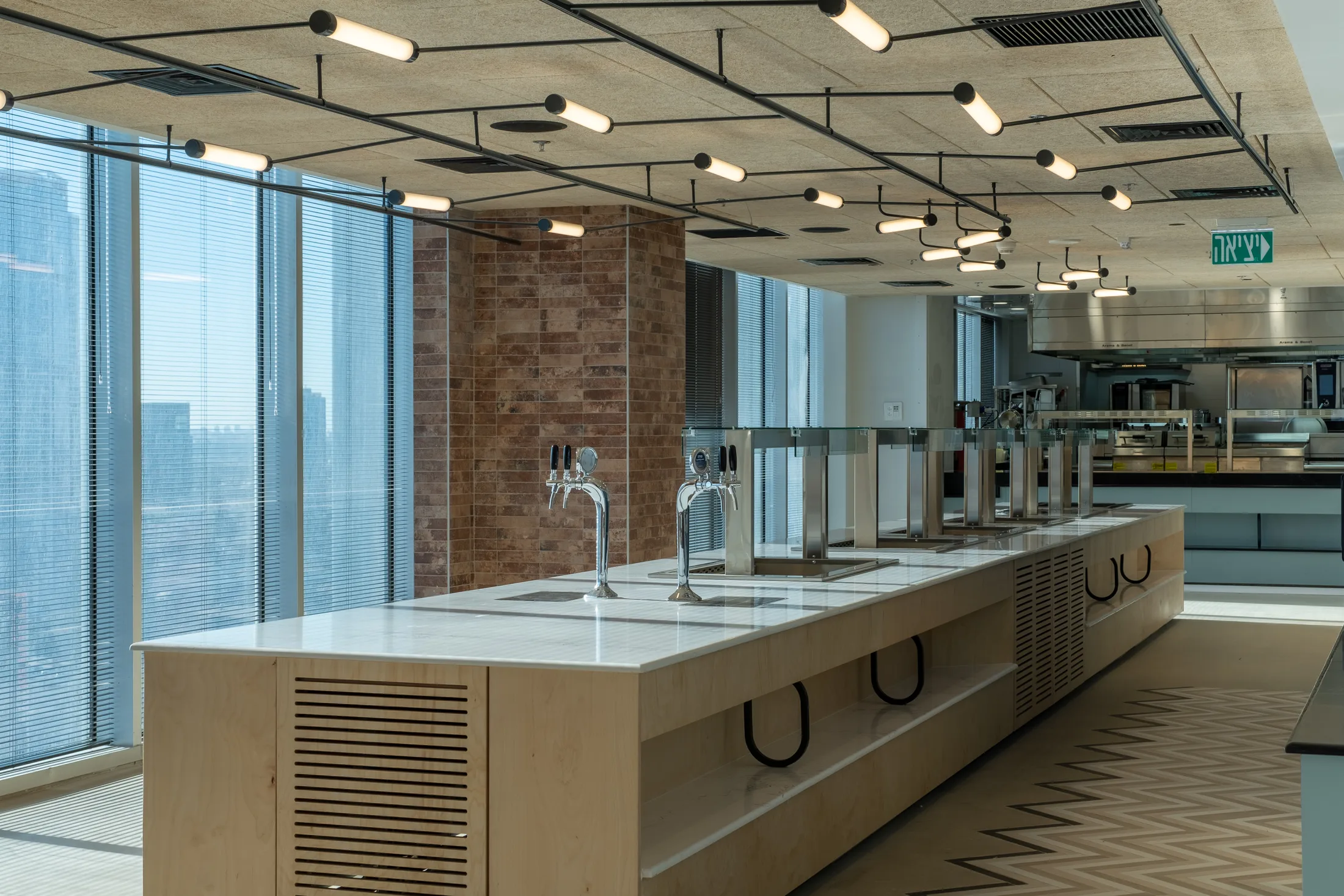 A pantry with a white island and sinks and suspended linear lighting