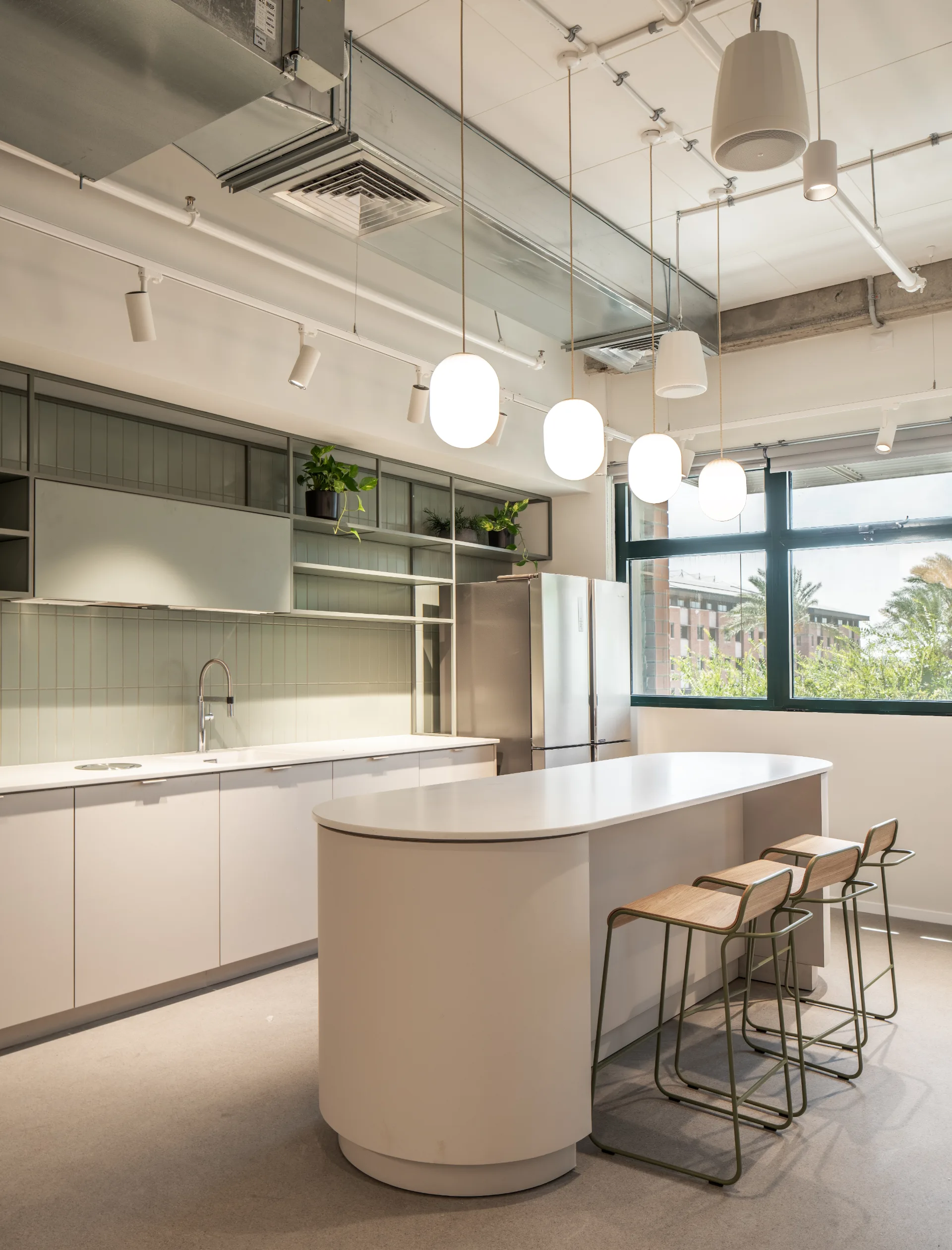 Kitchenette with a white island and pendant lights