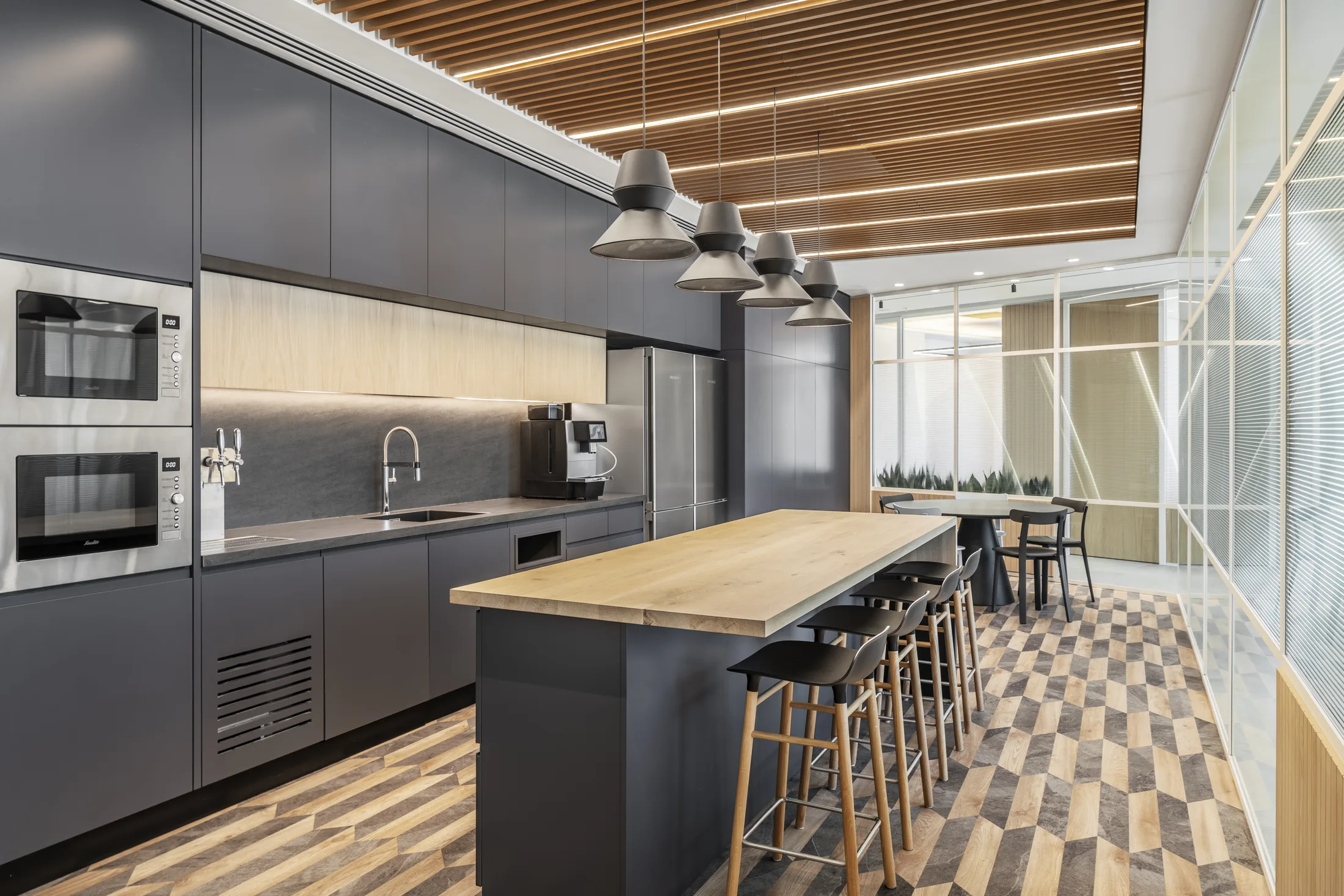 A kitchen with a cluster of dome pendants over the wood island and a lit slat ceiling