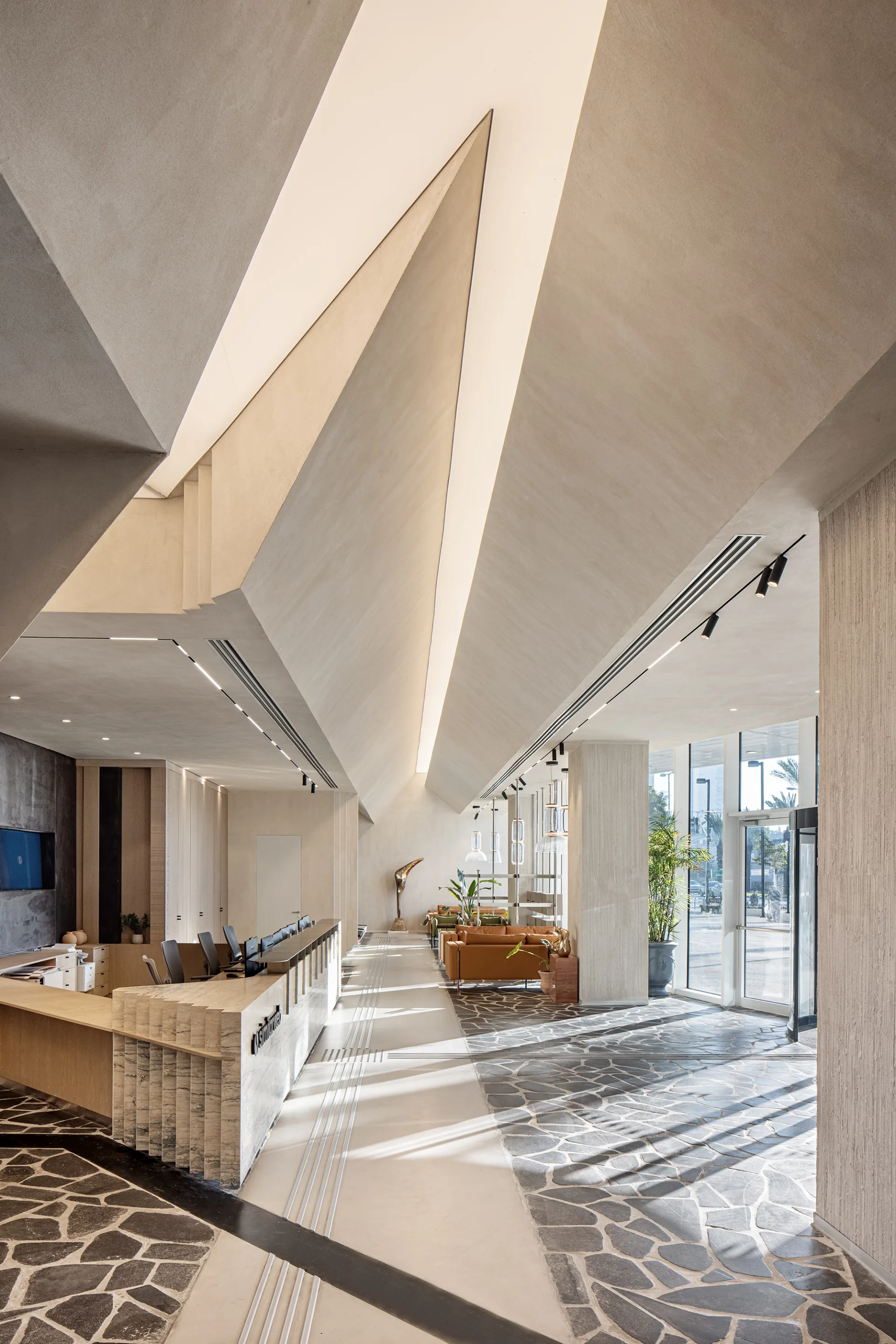 Faceted sculptural ceiling with integrated linear lighting