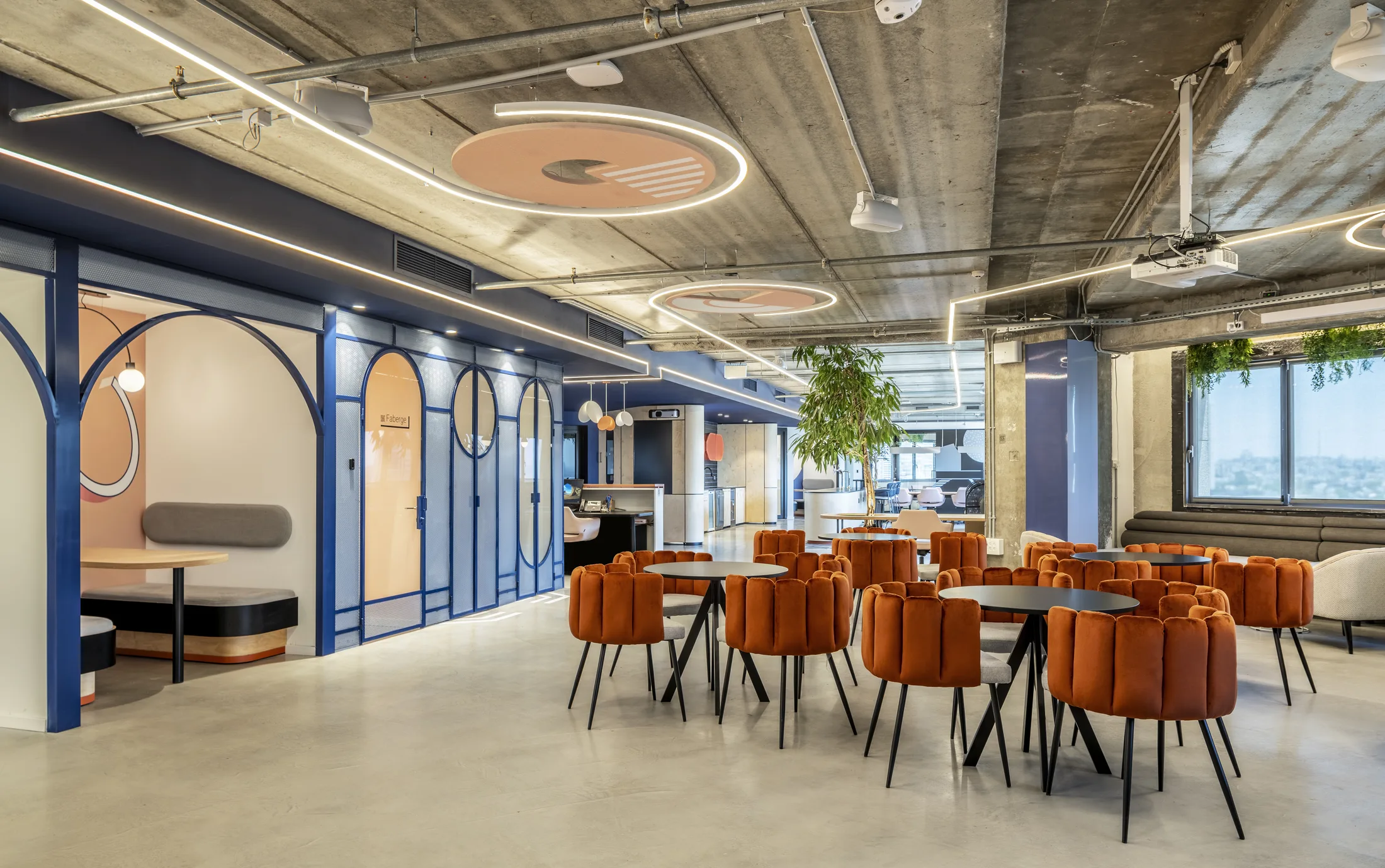 Café tables beside the blue arched booths