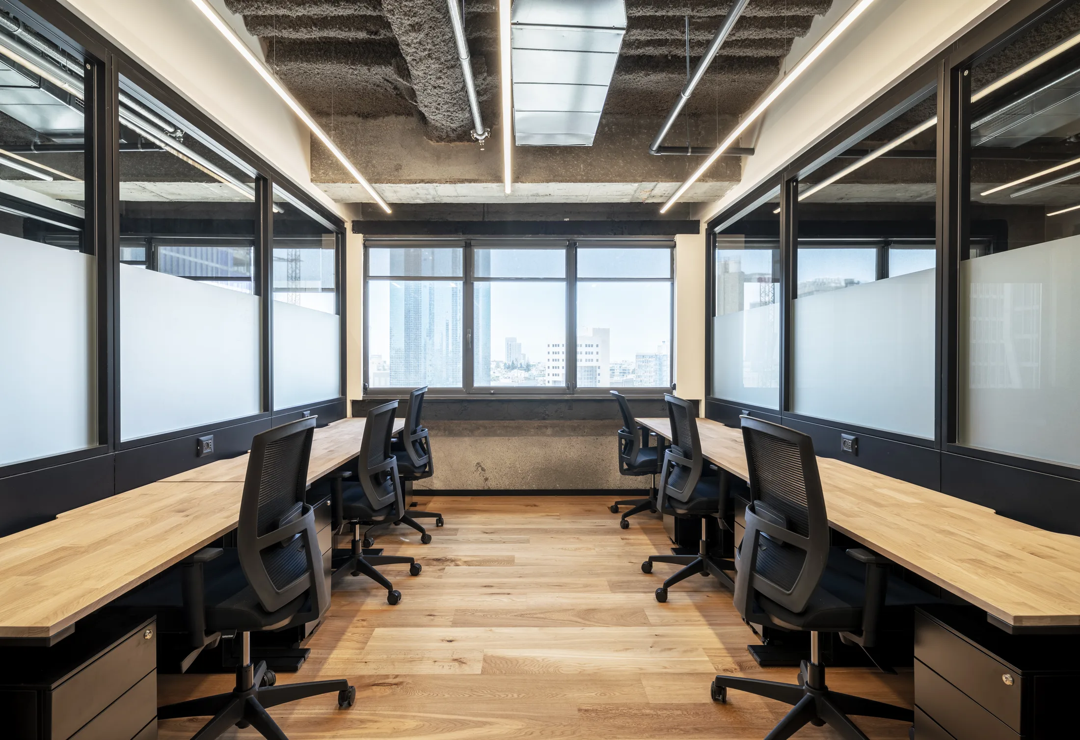 A private team office with linear lighting and a city view