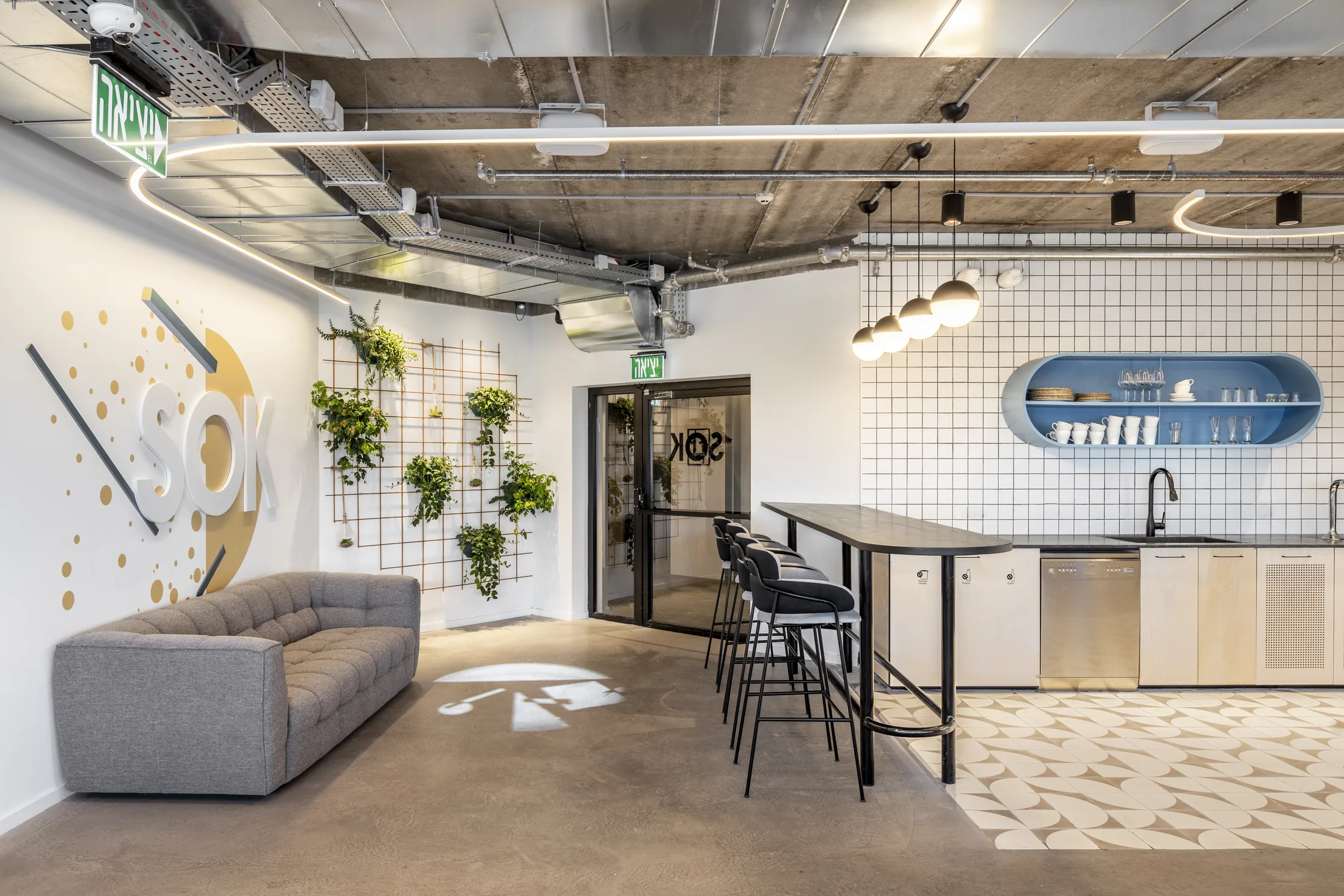 A lounge and kitchenette with a snaking ceiling light