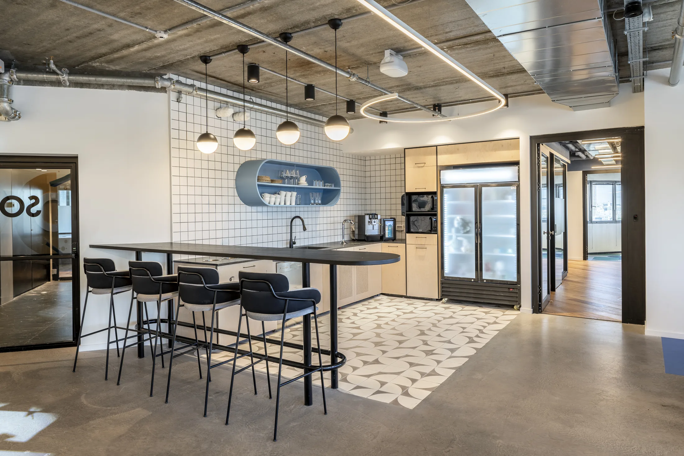 The kitchenette and bar with globe pendants and a curved light