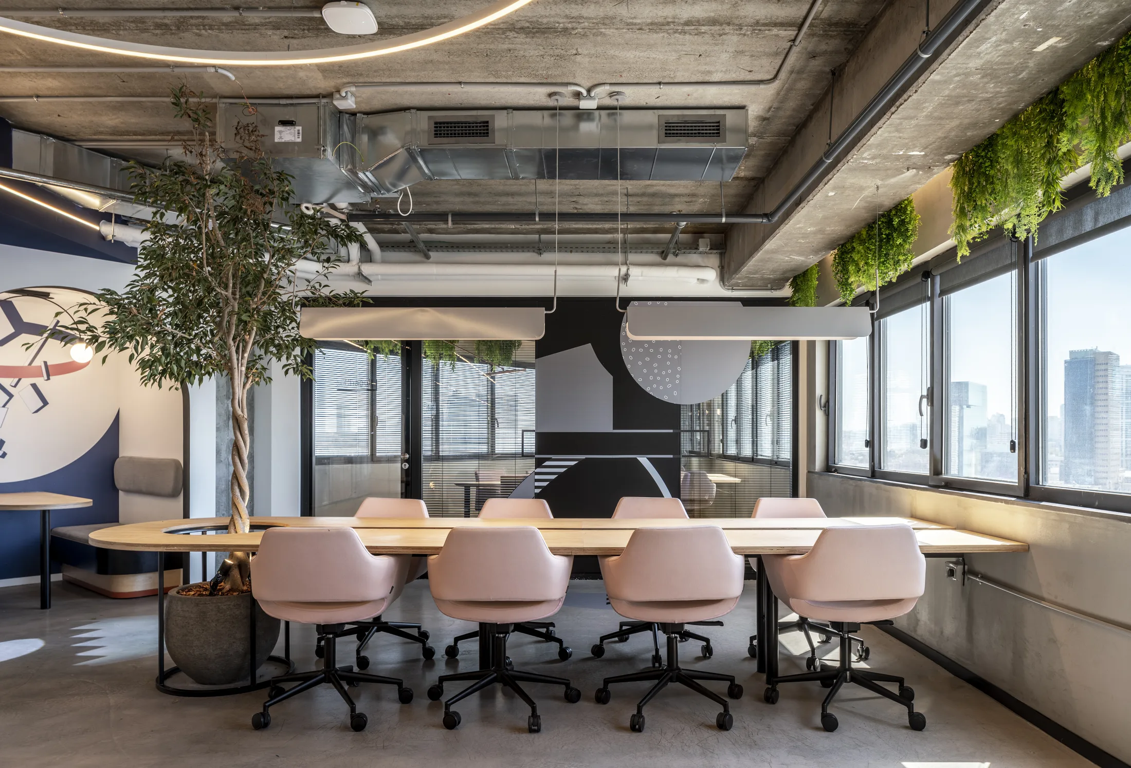 A boardroom with curved linear light and hanging greenery