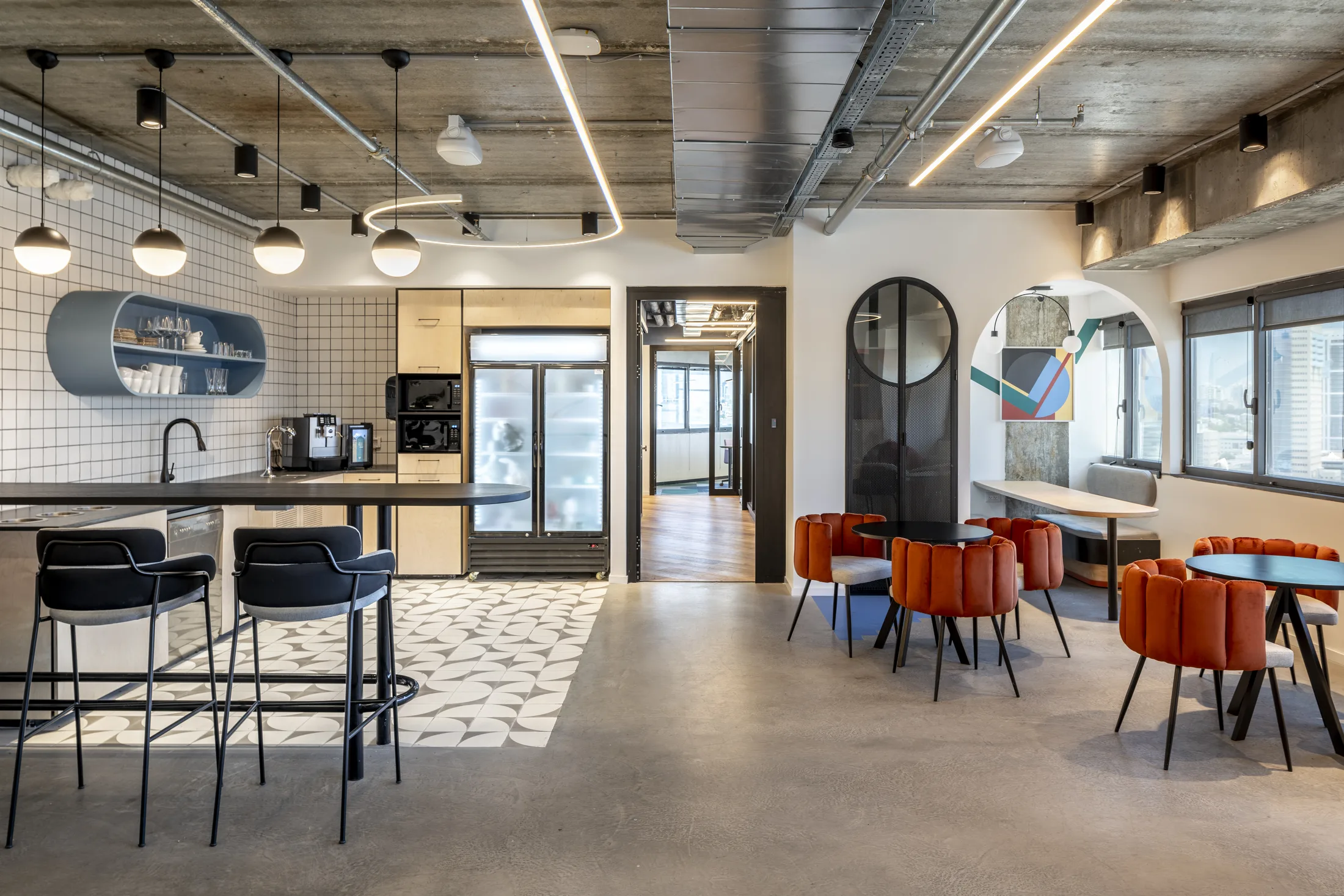 The café and kitchenette with globe pendants and an arched mirror