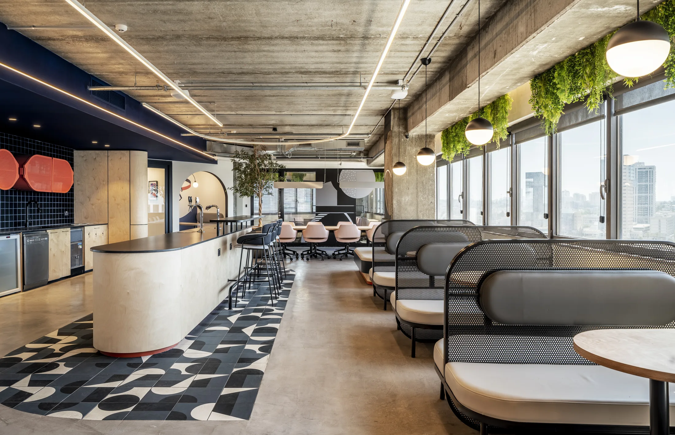 The café with a curved bar, booths, and globe pendants