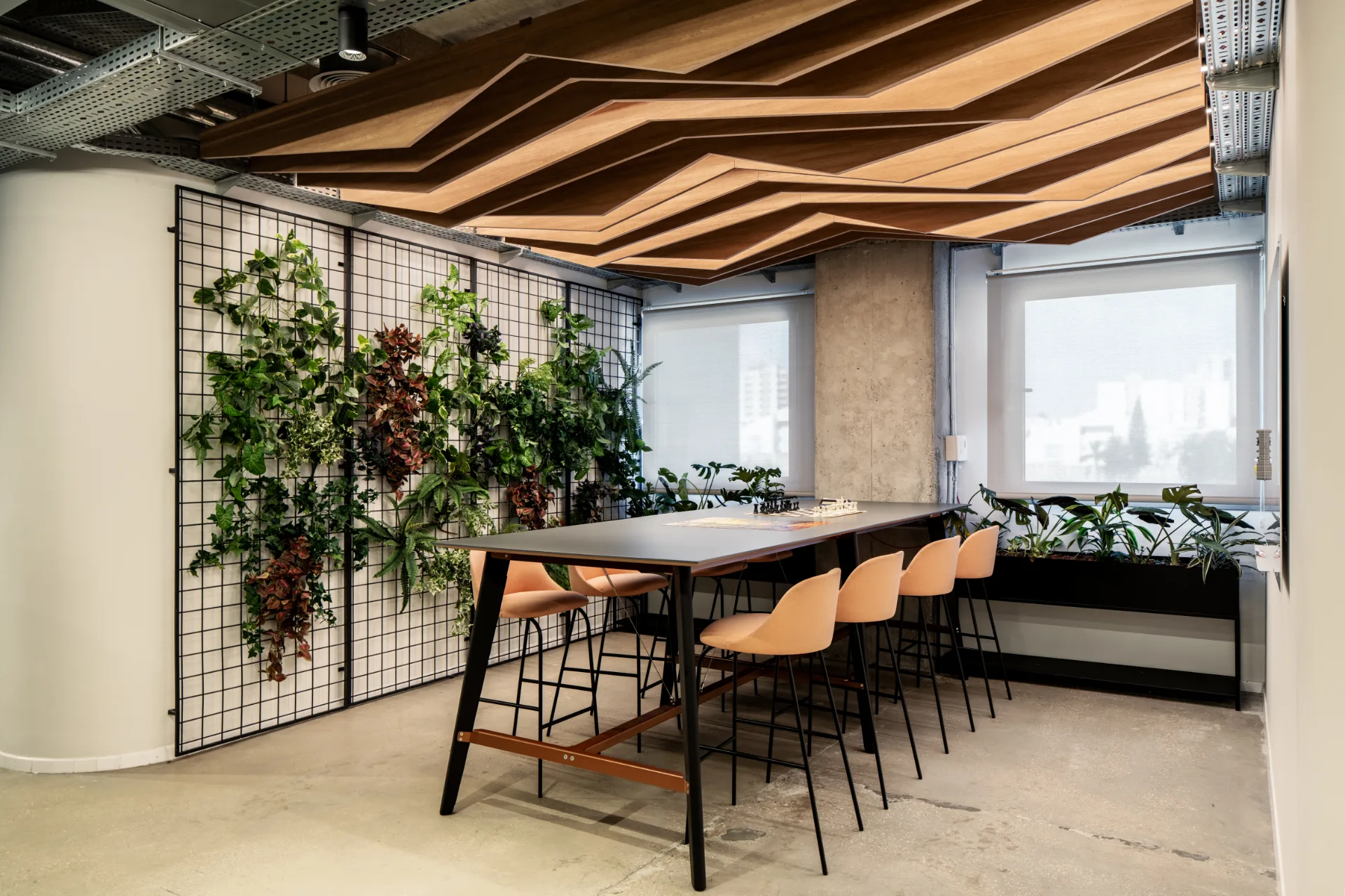Collaboration table beneath a sculpted timber ceiling and green walls