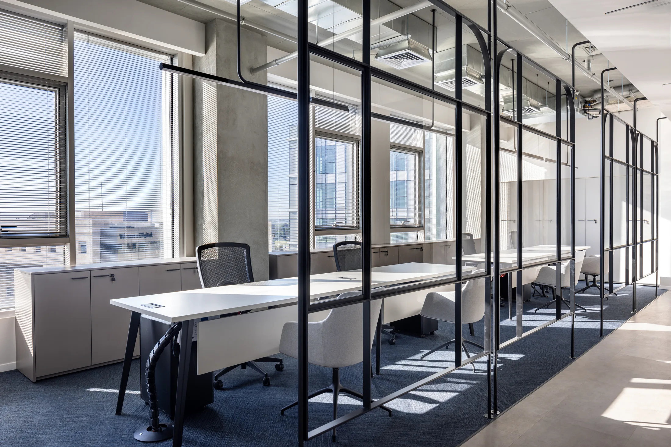 Workstations along the windows behind steel-frame partitions
