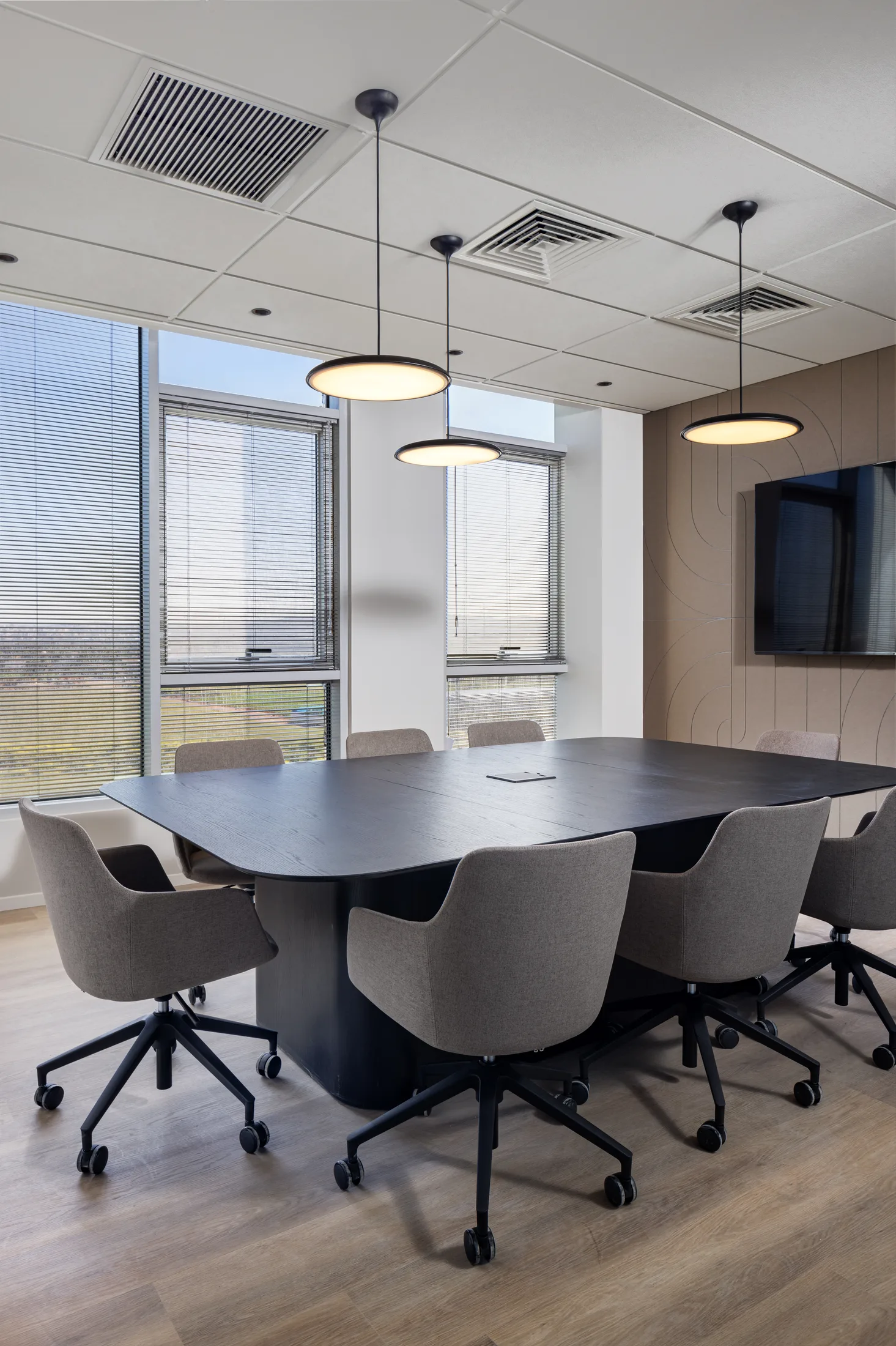 A small meeting room with drum pendants and a timber wall