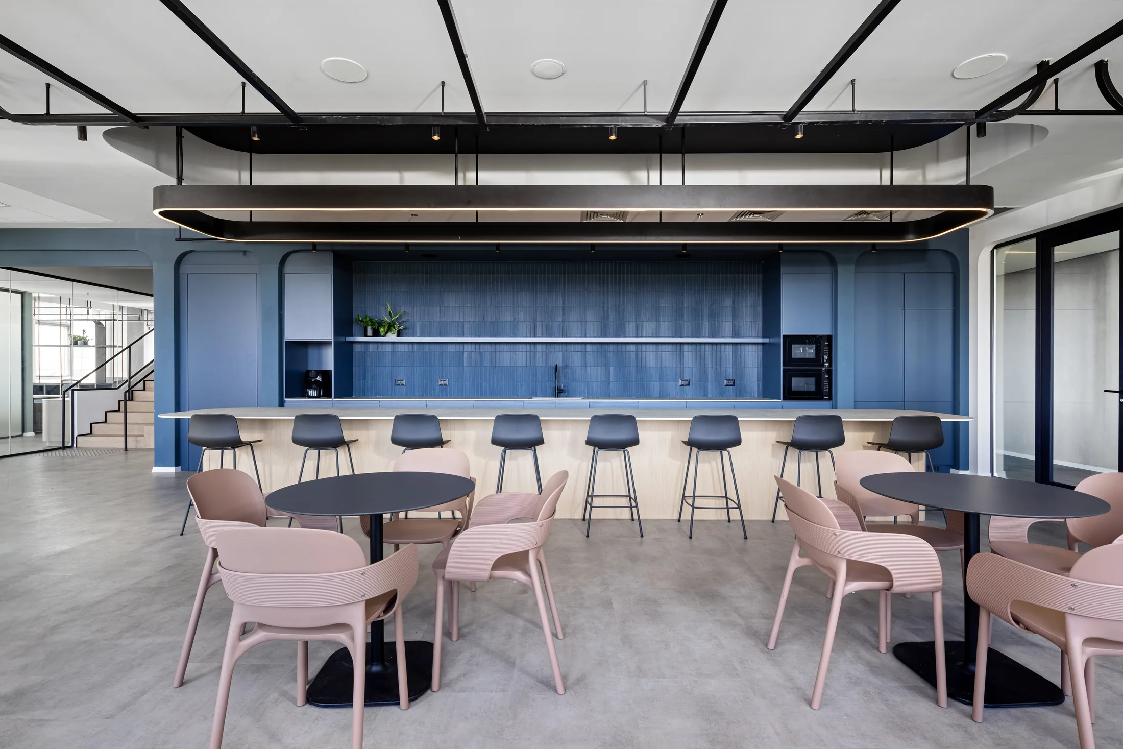 The café and kitchen with blue cabinetry and pendant lighting