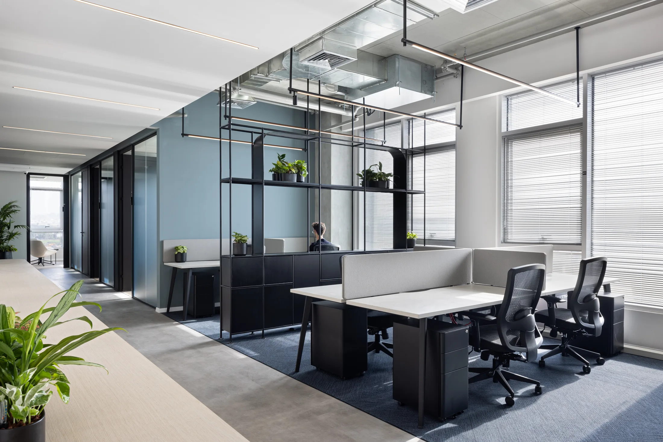 Open workspace with steel-frame partitions and planting