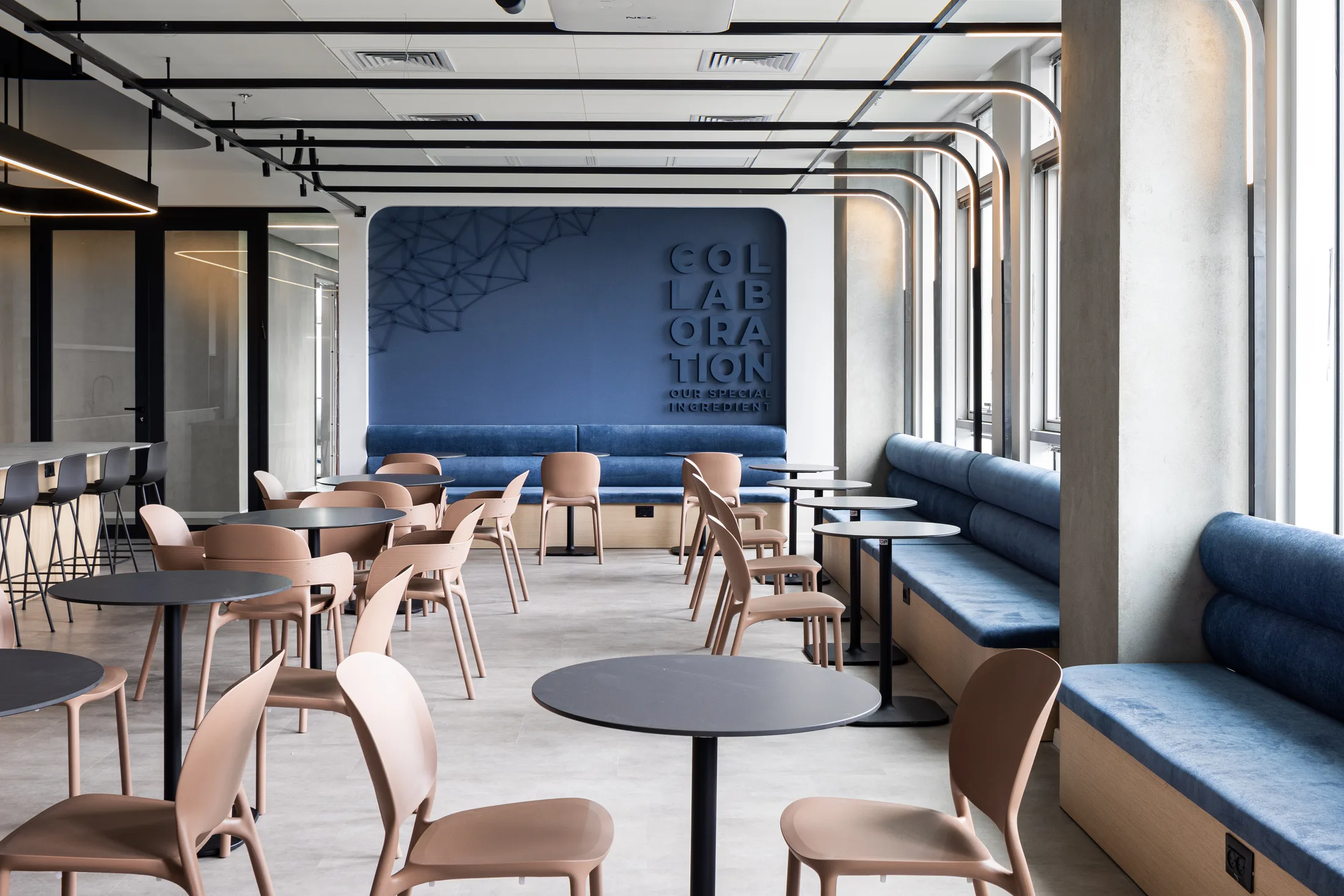 Café seating along blue banquettes by the windows