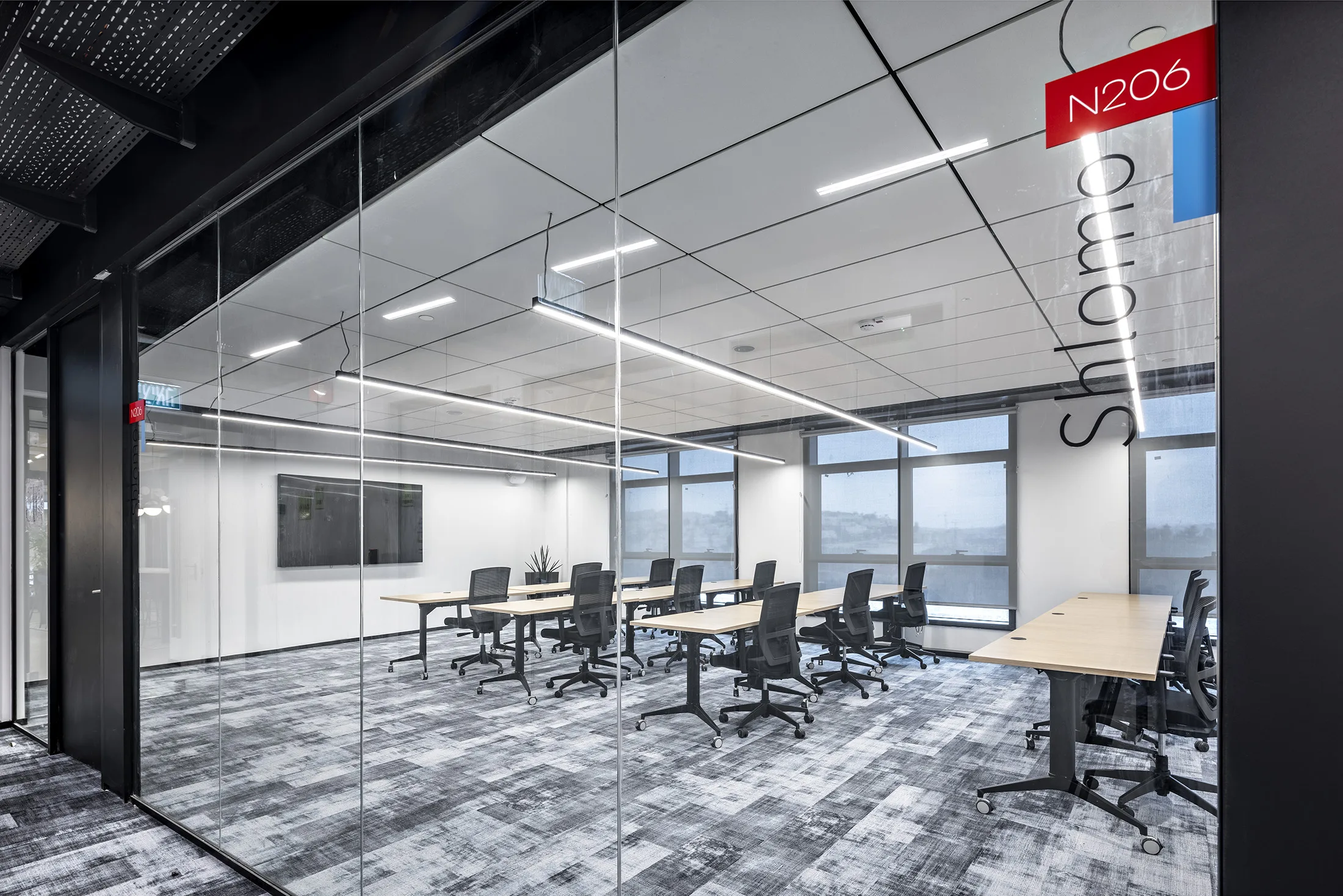 A meeting room with suspended light lines and a window view
