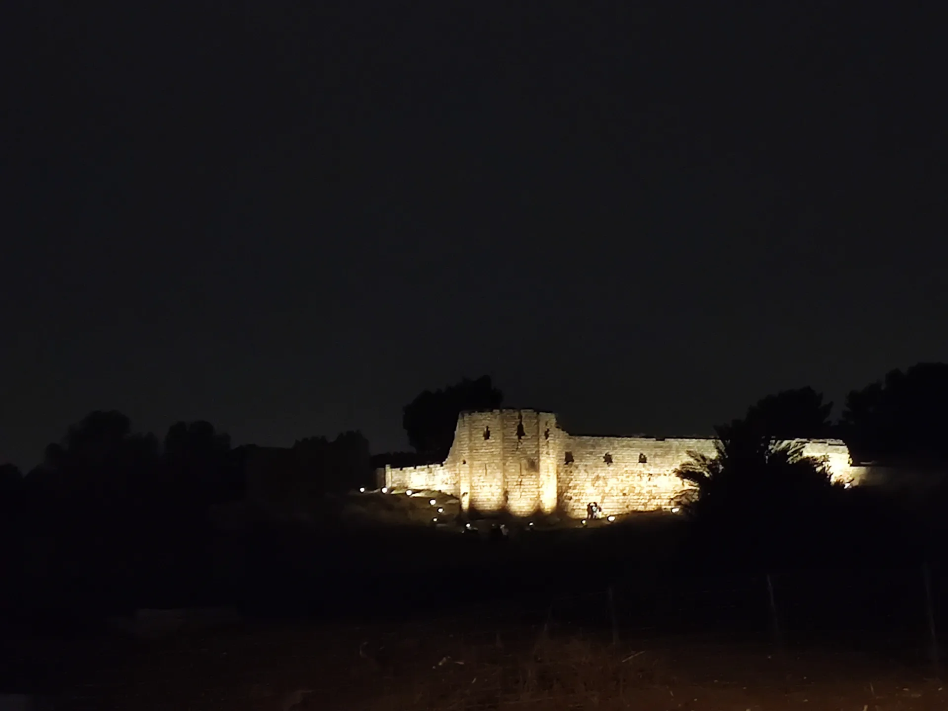 The lit fort walls glowing across the dark park