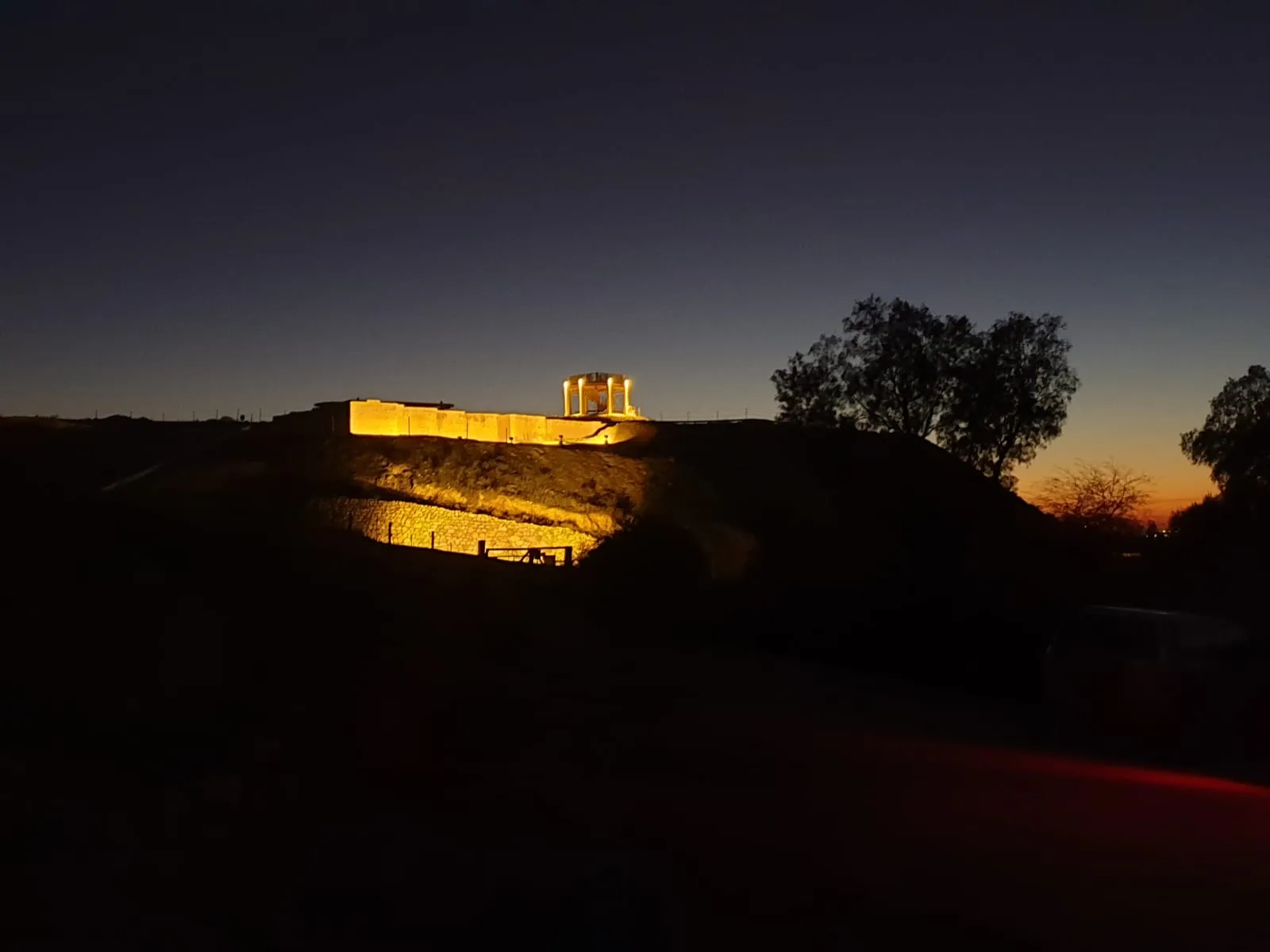 The illuminated tel and its walls at dusk