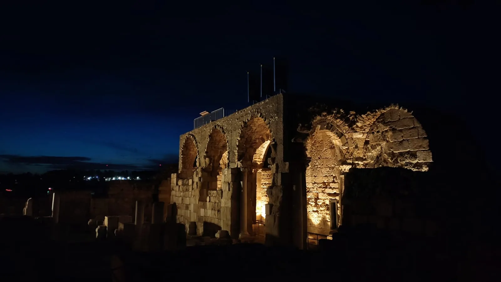 Arches and a ruined vault lit at night