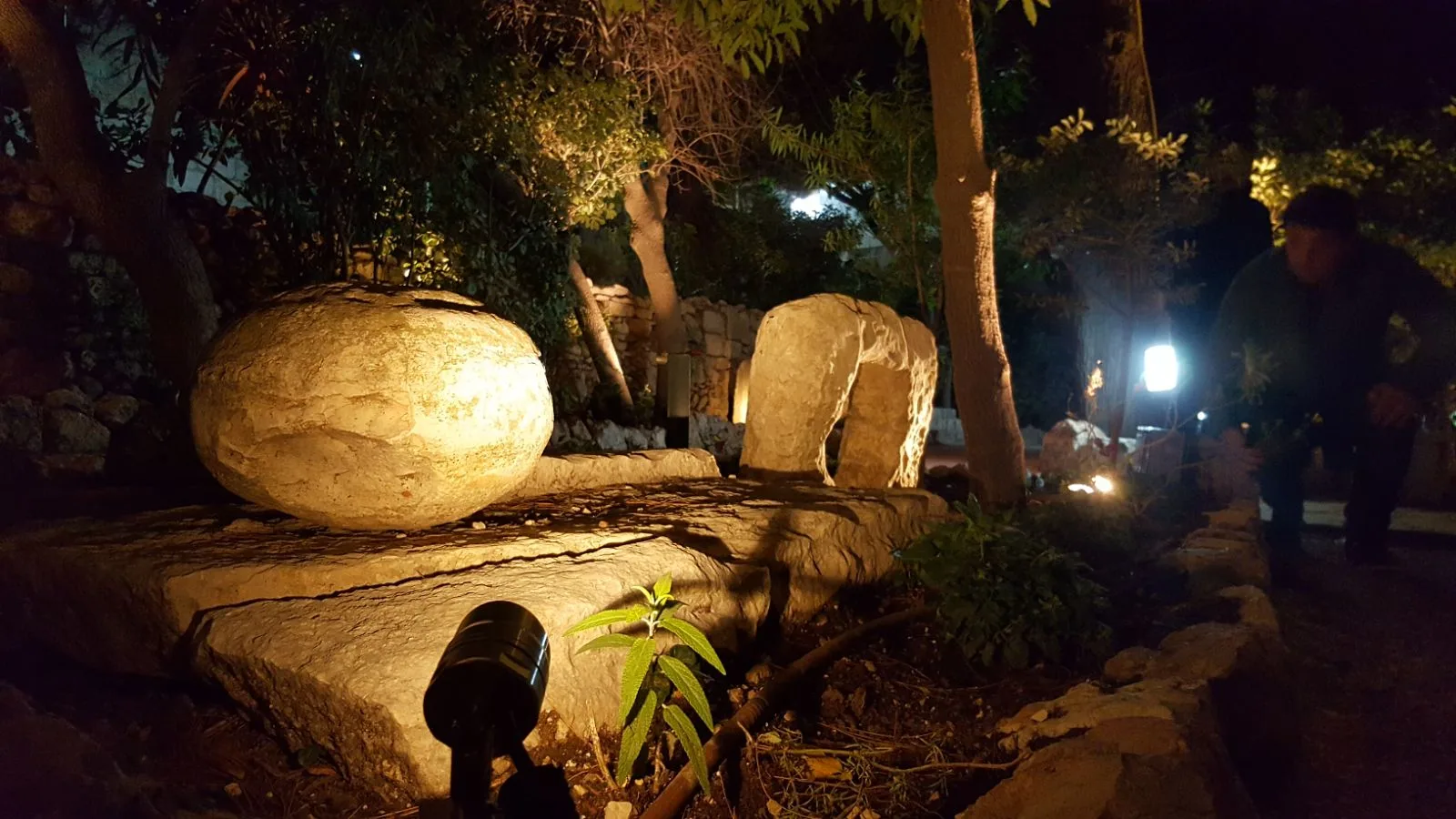 The rolling stone and burial slab lit at night