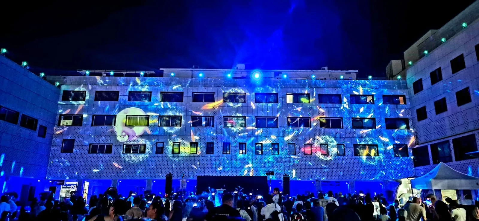 Blue projected imagery and beam lighting over the crowd