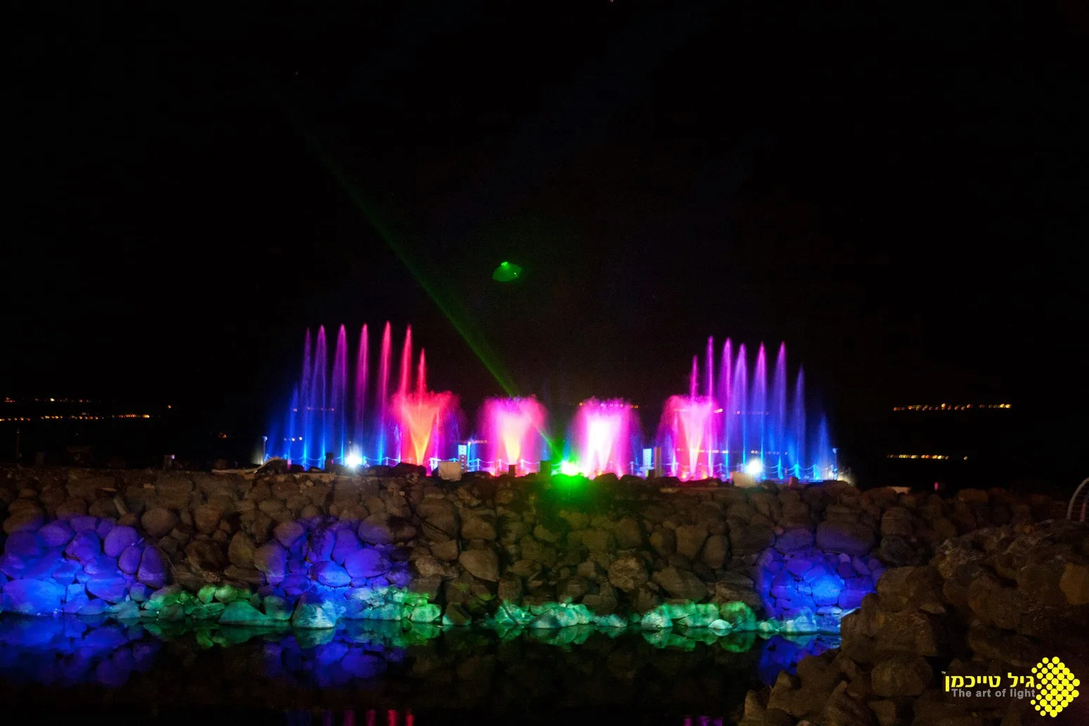 Multicolored water jets with a green laser beam