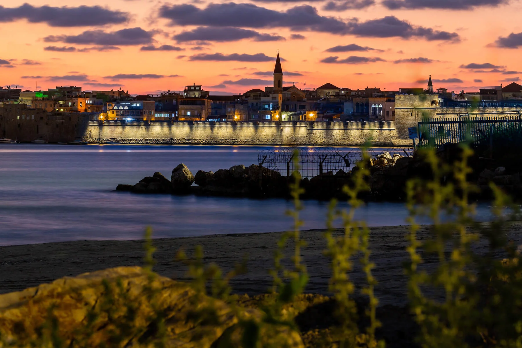 Walls of Acre by the sea at sunset
