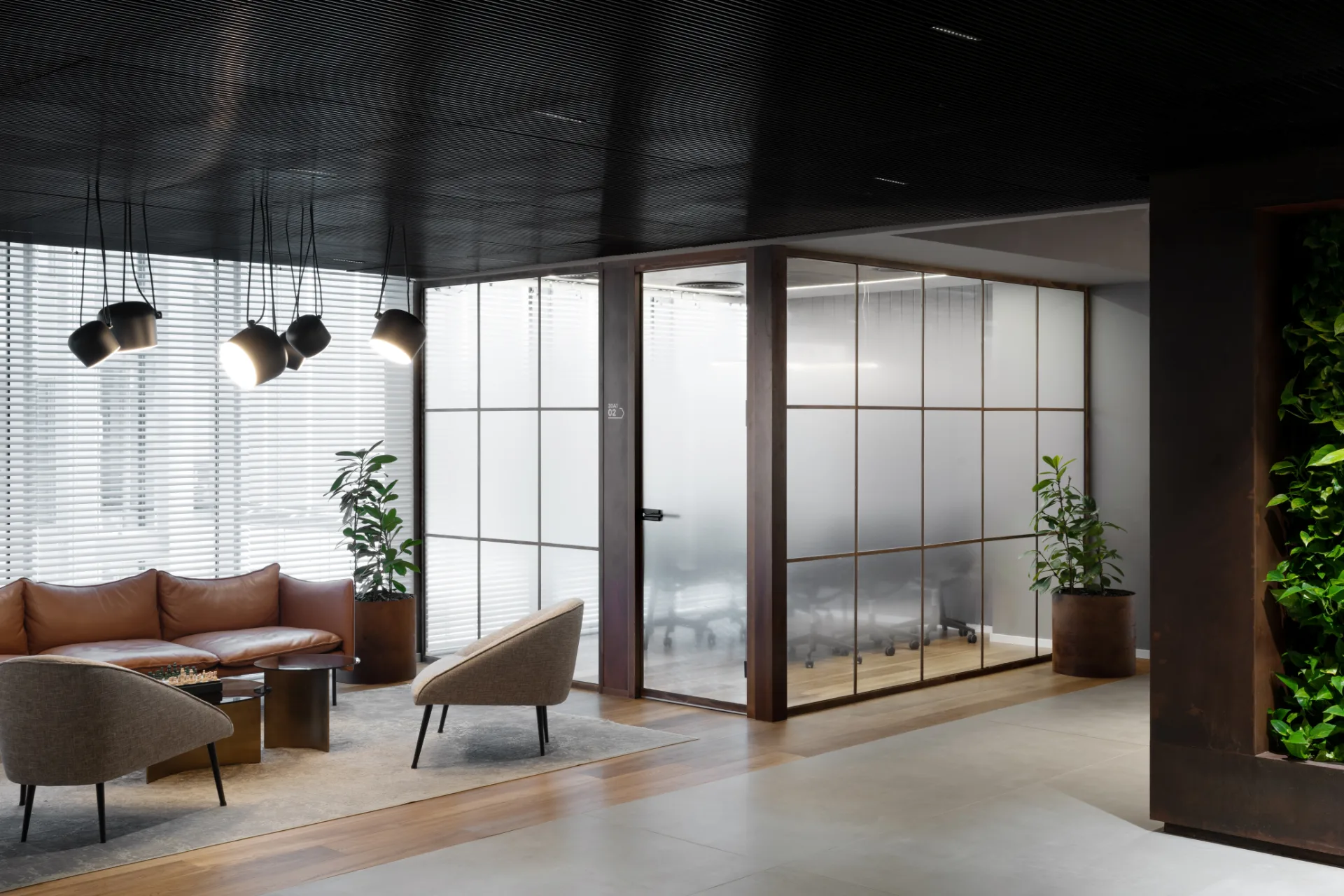 Lounge with a cluster of pendant lights and a glazed partition