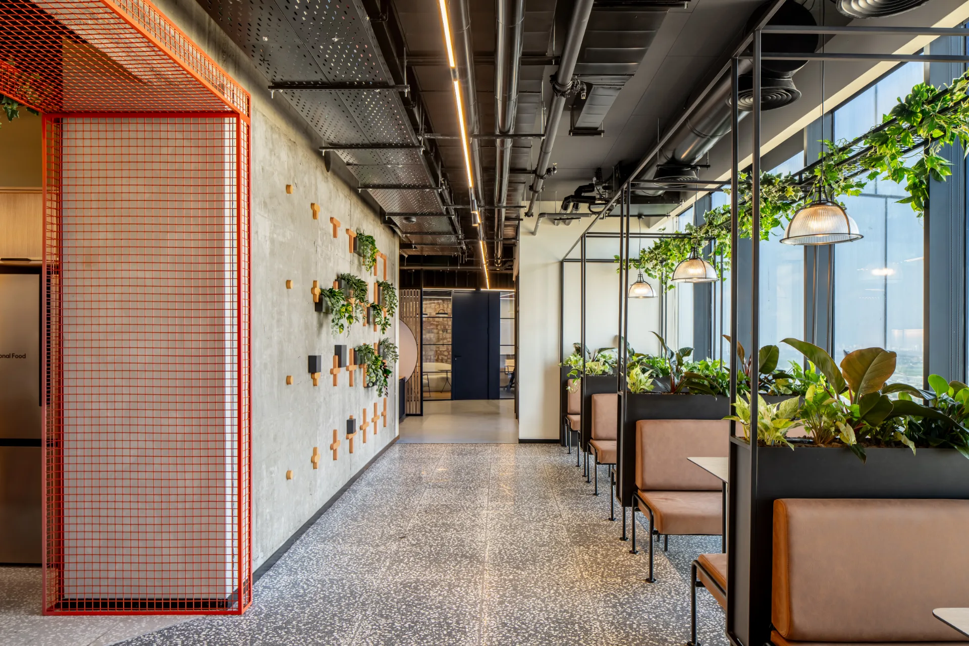 Seating corridor with a red mesh screen and planting